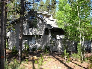 Surrounded by lush forest, this two-story house offers a serene retreat.