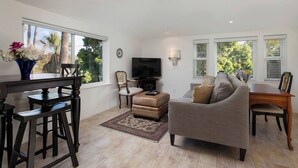 A living room with a sofa, TV, and a dining area with a table and chairs.
