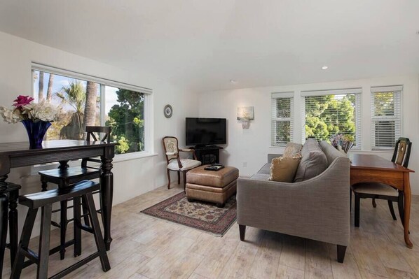 A living room with a sofa, TV, and a dining area with a table and chairs.