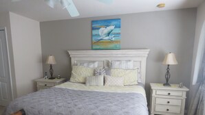 A neatly arranged bedroom with a large bed, two bedside tables, and a chair. - 5 Star - 5 BR/4 Bath Villa - Perfect for Family vacation. Minutes to Disney. (Clermont)