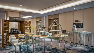 Una sala riunioni moderna con una macchina per Nespresso, un buffet e una macchina del caffè.