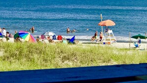 Une plage où l’on peut se baigner et bronzer, avec des parasols et un poste de surveillance pour les sauveteurs.