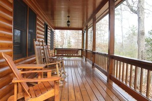 A wooden cabin with a porch, wooden chairs, and a bench. - Affordable! Mtn Views, Game Room, Hot Tub, Amenities & More (Blue Ridge)