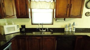 A kitchen with wooden cabinets, a microwave, a sink, and a dishwasher. - A Short Walk to Dauphin Island Beach.*Pets Welcome* 
special rates 20% Discount  (Dauphin Island)