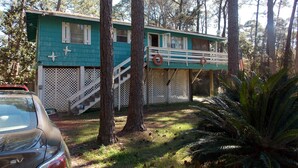 A two-story house with a balcony, surrounded by trees and a car parked in front. - A Short Walk to Dauphin Island Beach.*Pets Welcome* 
special rates 20% Discount  (Dauphin Island)