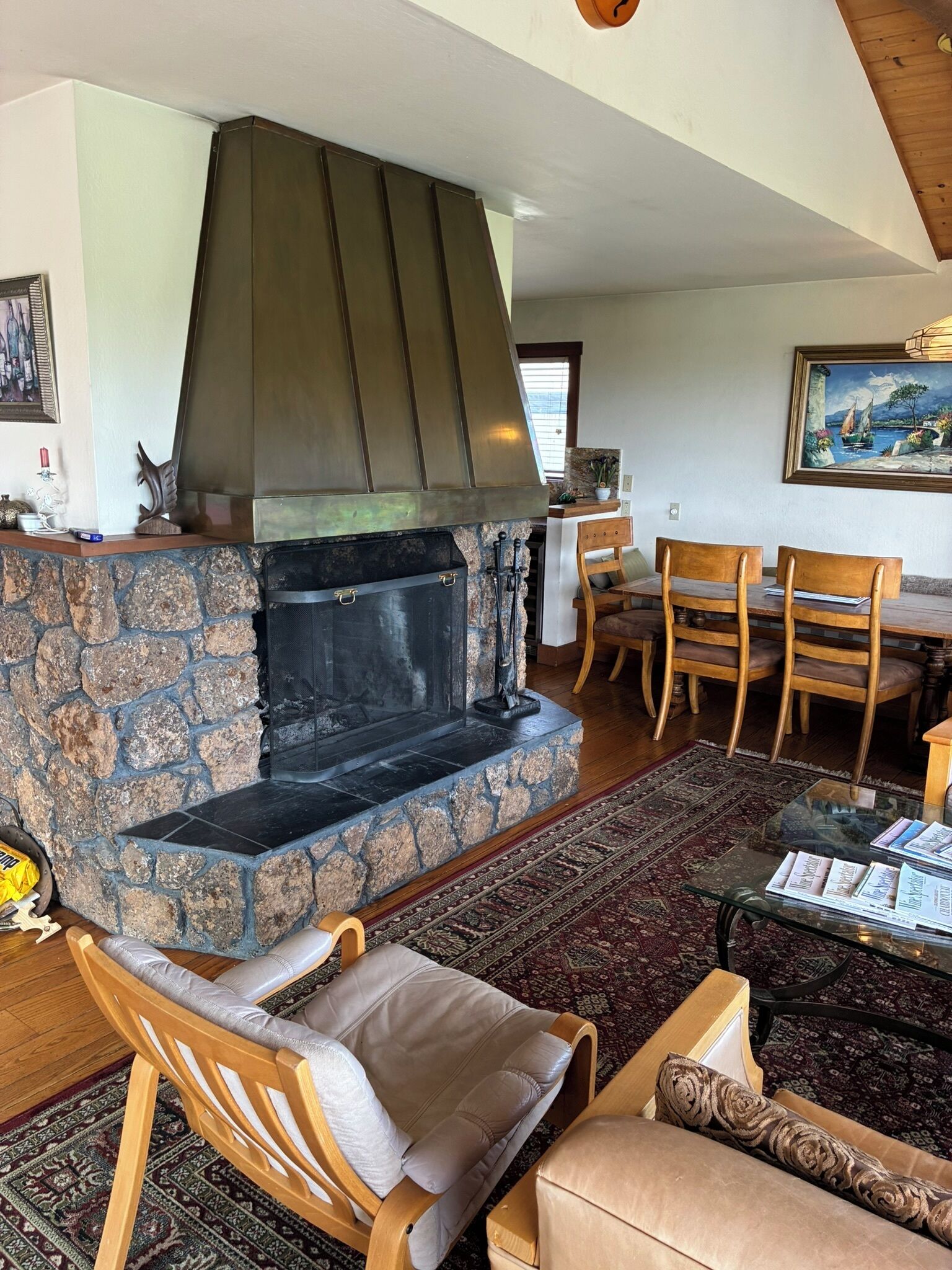 Un salon chaleureux avec une cheminée en pierre, des meubles en bois et un coin repas.