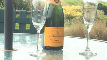A bottle of Veuve Clicquot Ponsardin Brut champagne on a table with two empty glasses.
