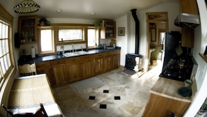 A kitchen with wooden cabinets, a large island, a stove, and a sink. - Mountain View Chalet - Fantastic Views and Privacy  (Blackhawk)