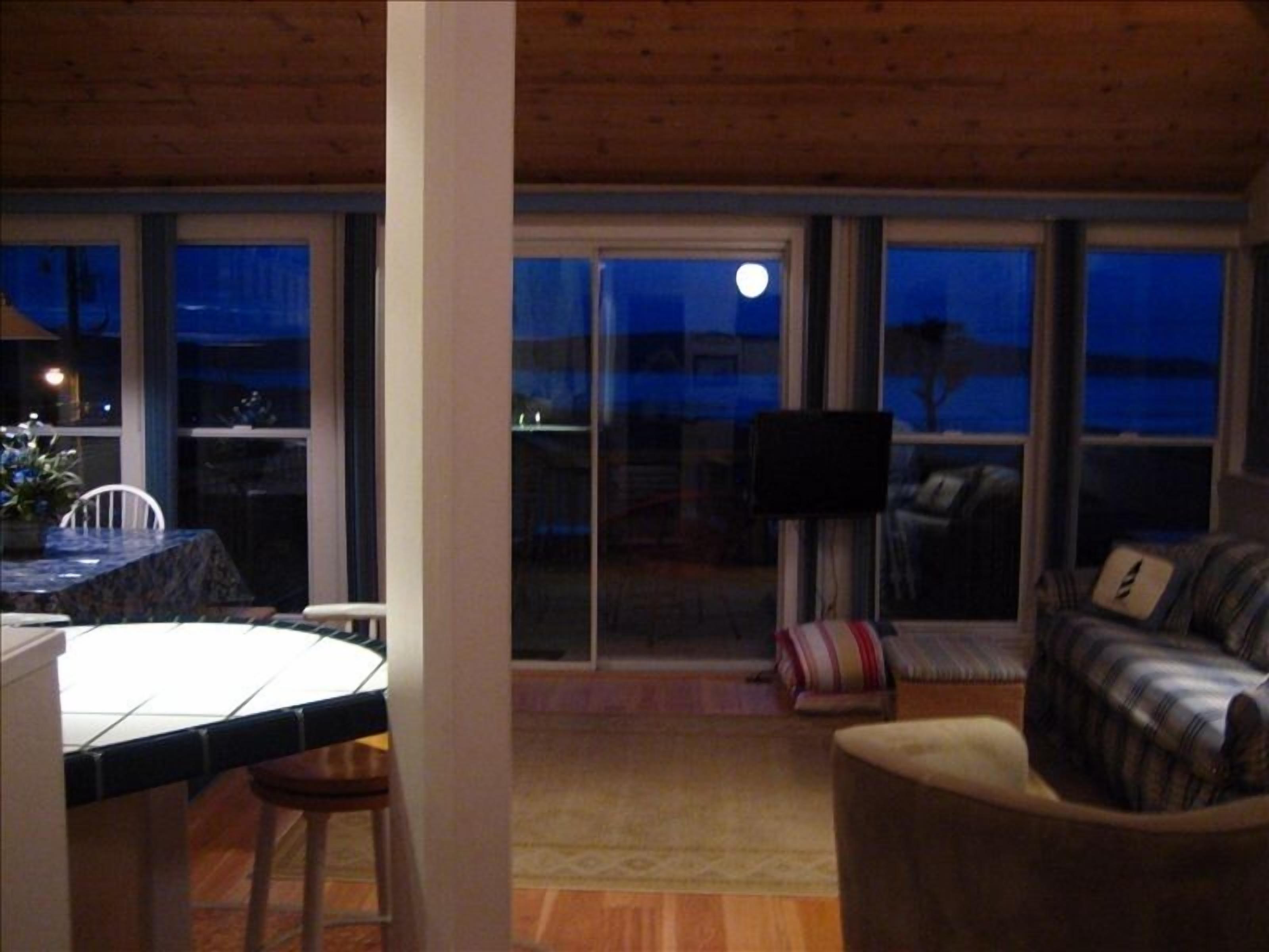 A dining area with a table and chairs, a sofa, and a television.