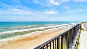 Vista de una playa con un pasillo de madera y barandilla.