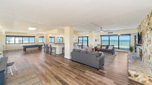 Un salón amplio con un sofá grande, una mesa de comedor y una chimenea de piedra.