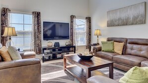 A living room with a sofa, coffee table, and TV. - South facing pool,spa, communal pool, interior games room, Wifi, monitored alarm (Kissimmee)