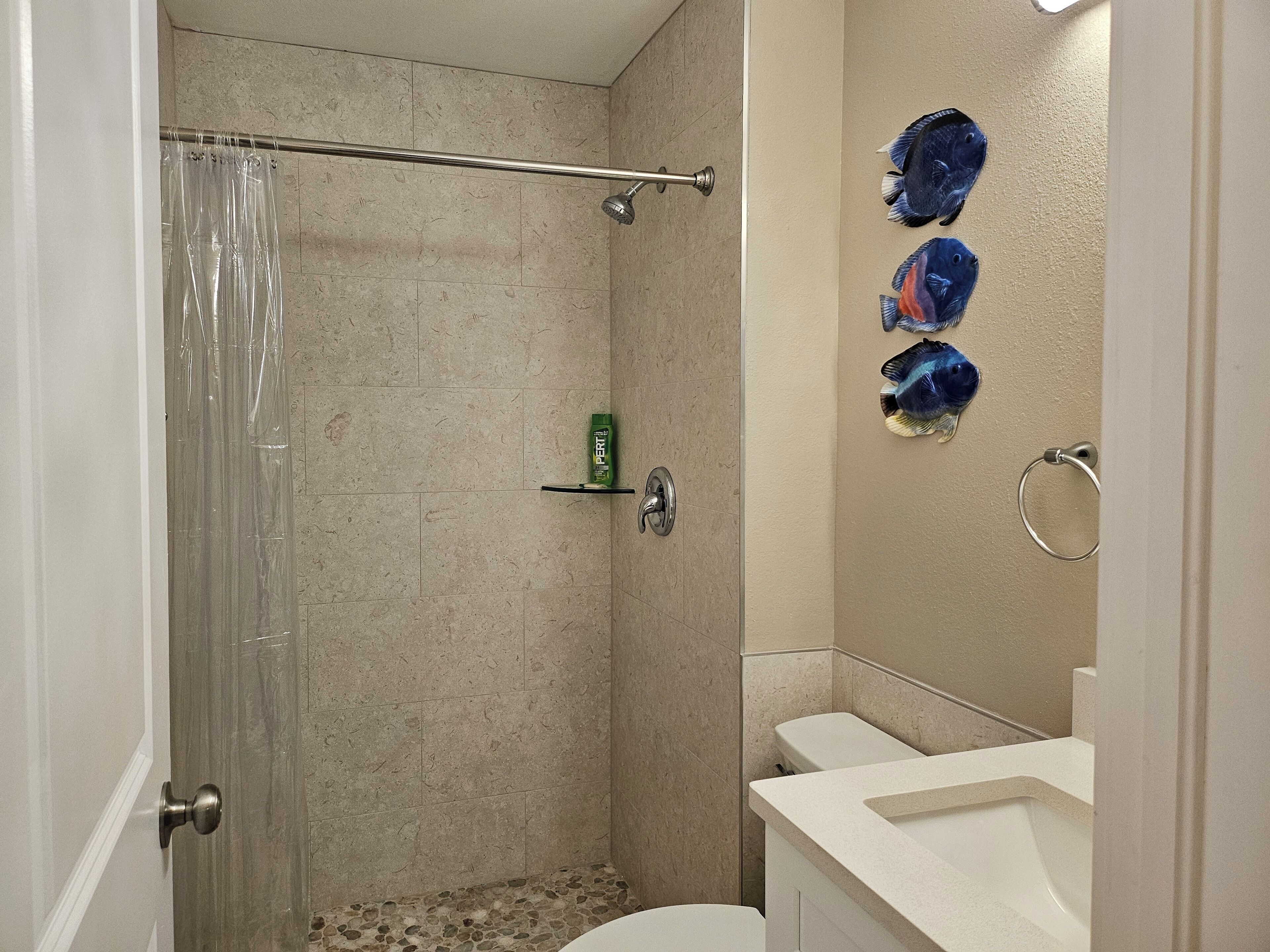 A bathroom with a shower, toilet, and sink.