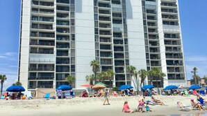 Un hotel moderno con múltiples balcones y ubicación frente a la playa.