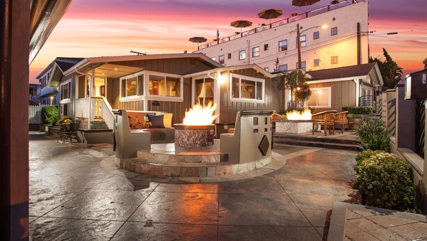 A patio area with a fire pit, outdoor seating, and umbrellas. - Beautiful Ocean View! Steps to Sand! Private Home with 3 Car Driveway! (Laguna Beach)