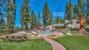 A resort with a pool, picnic tables, and a walking path.