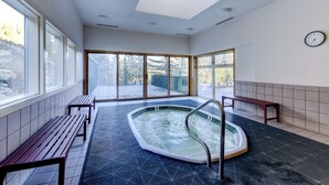 A spa room with a hot tub, benches, and large windows. - Amazing Views-Free shuttle, Lodge access pool/gym. (Keystone)