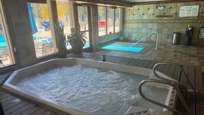 A hot tub with a metal ladder, wooden deck, and a view of a pool and outdoor seating area. - Amazing Views-Free shuttle, Lodge access pool/gym. (Keystone)