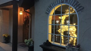 A building entrance with a large arched window displaying a light sculpture.