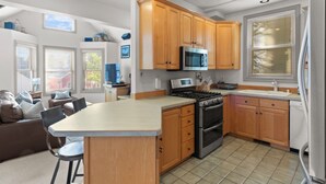 Een moderne keuken met houten kastjes, een roestvrijstalen fornuis en een groot eiland.