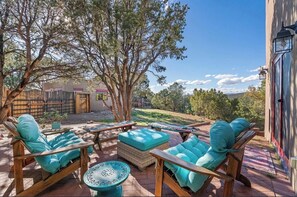 An outdoor patio with wooden furniture and a view of a building in the background.