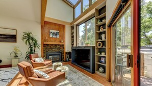 A modern living room with a fireplace, leather chairs, a large window, and a wooden floor. - Pearl st, A/C, Fireplace, Views and Decks- Winner (Boulder)