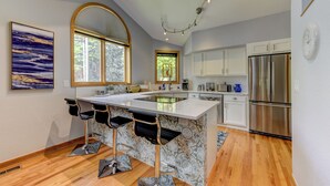 A modern kitchen with a central island, bar stools, stainless steel appliances, and a large window with a view. - Pearl st, A/C, Fireplace, Views and Decks- Winner (Boulder)