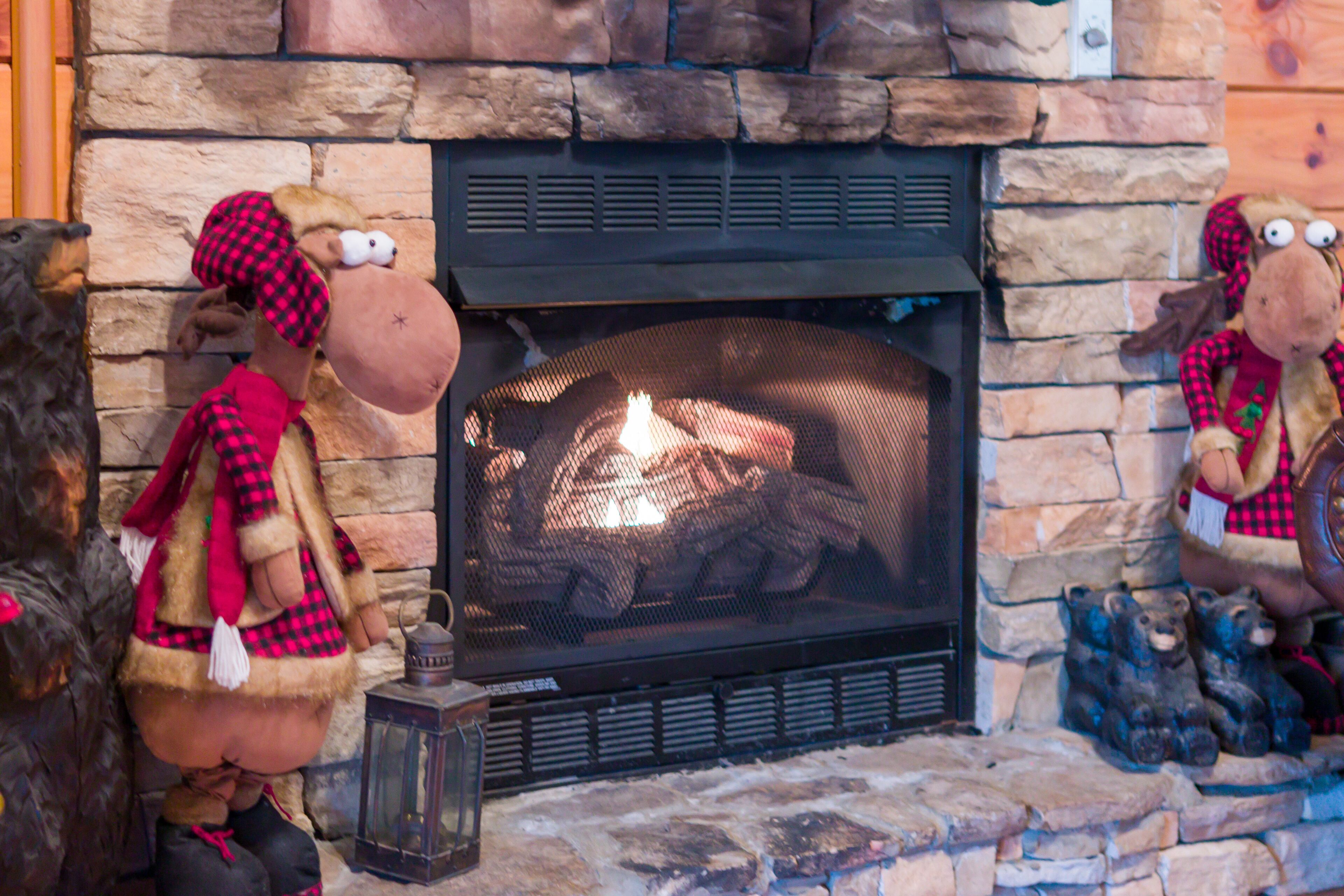 A fireplace with bear decorations and a lantern.