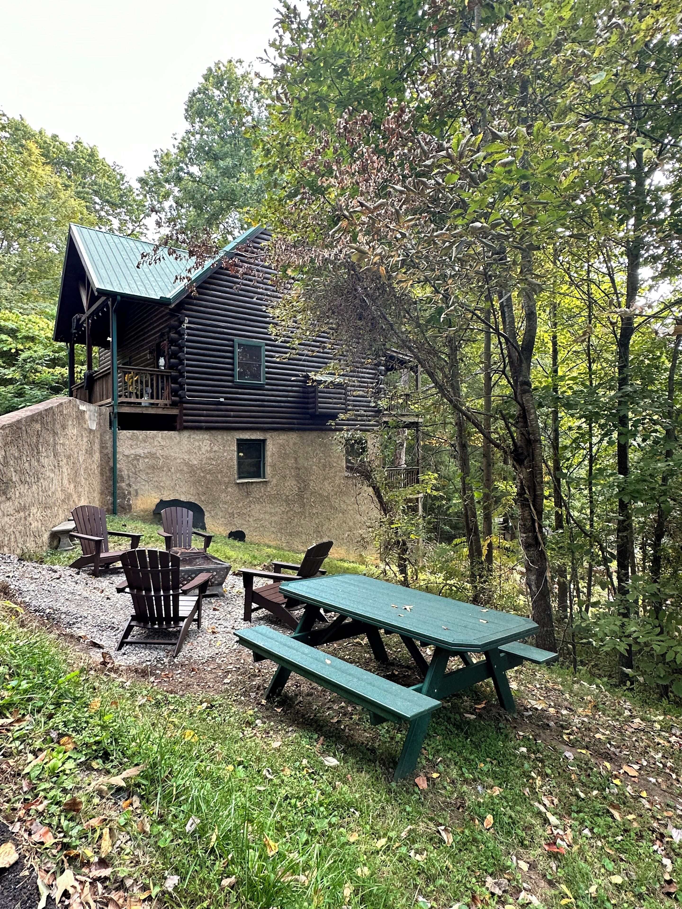 A rustic cabin with a porch, a picnic table, and outdoor seating.