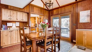Un intérieur en bois comprenant une table à manger, des chaises et un lustre.