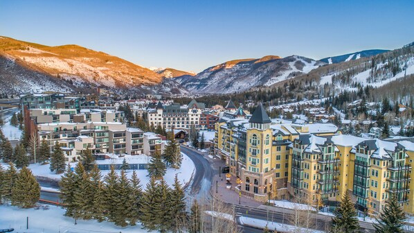 A snow-covered mountain town with a prominent hotel featuring multiple floors and a tower.