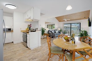 Een moderne keuken met witte kasten, een ingebouwde magnetron en een houten aanrecht.