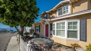 A two-story house with a patio, a red door, and a large window with shutters. - WALK to Beach, Pier and Downtown - Parking - BBQ - View (Pismo Beach)
