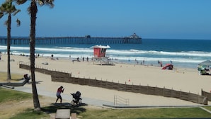 A beach with a lifeguard tower, a pier in the background, and palm trees. - PRICE REDUCTION! BEACH FRONT CONDO! 
San Diego-Imperial Beach-Coronado (Imperial Beach)