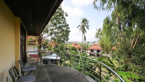 A balcony with a view of a residential area, including houses and palm trees. - 3 Bedroom Villa TG25 Beach Front Resort SDV282-By Samui Dream Villas (Koh Samui)