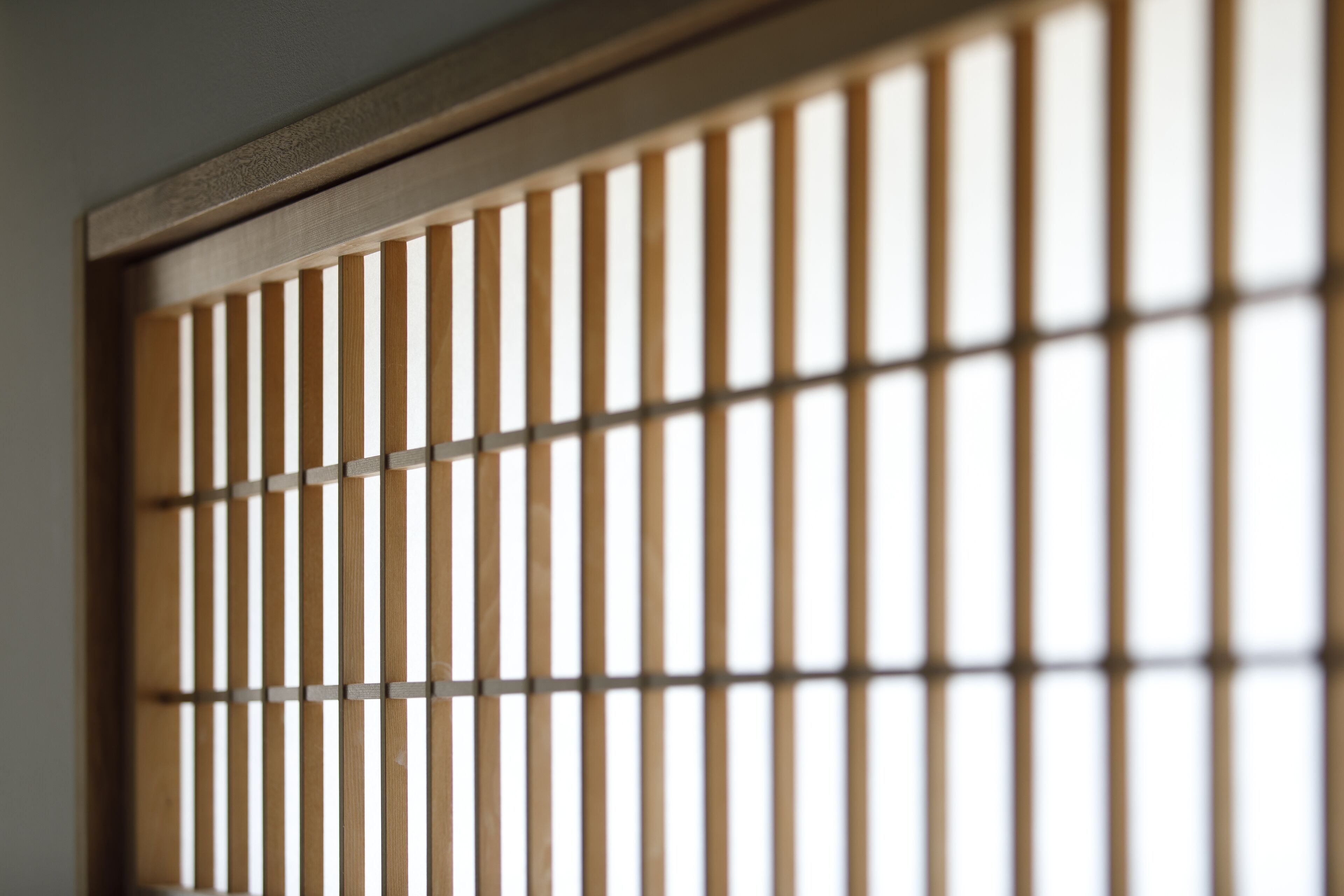 A close-up of a wooden shoji screen with vertical slats.