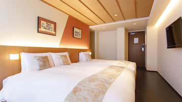 A hotel room with a large bed, wooden headboard, two wall-mounted lights, and a flat-screen TV.