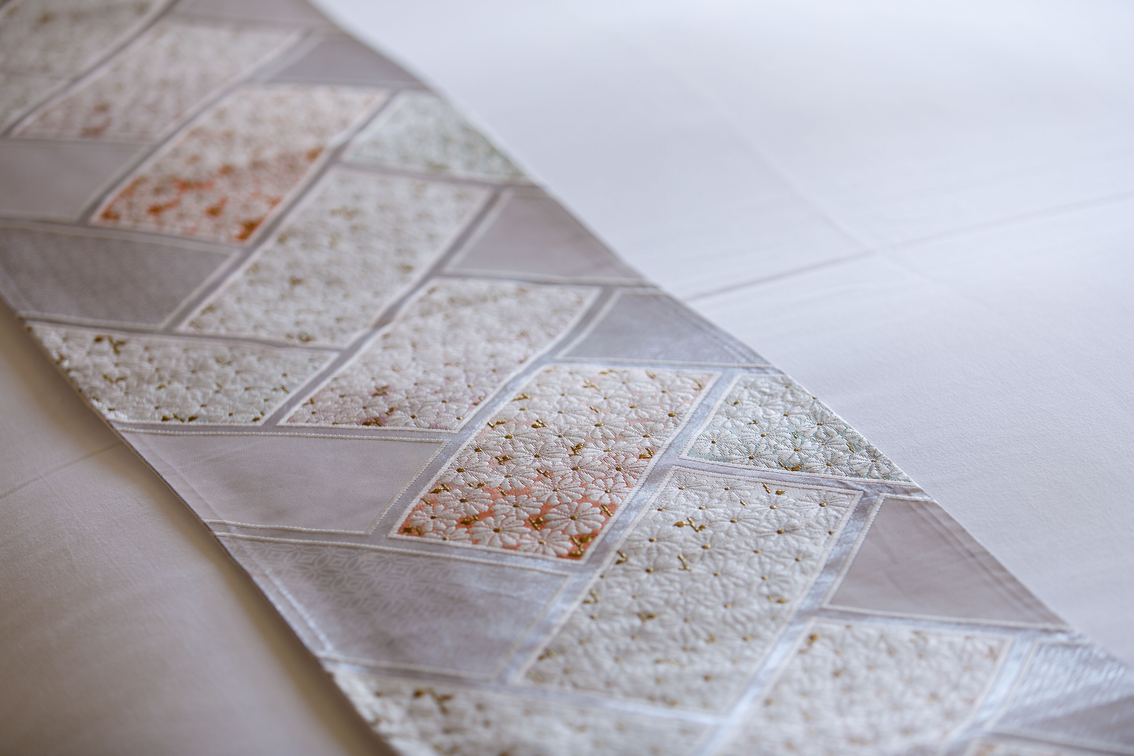 Primer plano de una tela estampada, probablemente un mantel o un adorno, con un diseño geométrico y una combinación de cuadrados lisos y estampados.