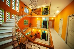 A multi-level interior with a spiral staircase, a reception desk, and a door leading to another room. - Fabhotel Hallmark Begumpet Railway Station (Hyderabad)