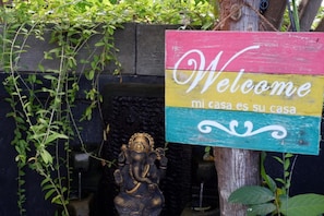 A colorful welcome sign with a decorative elephant statue and a tree trunk. - Akatara Stay Jimbaran (Jimbaran)