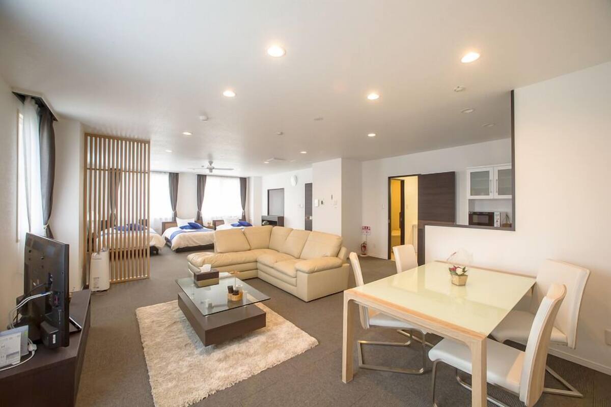 Una sala de estar moderna con un sofá, una mesa de comedor y un televisor.