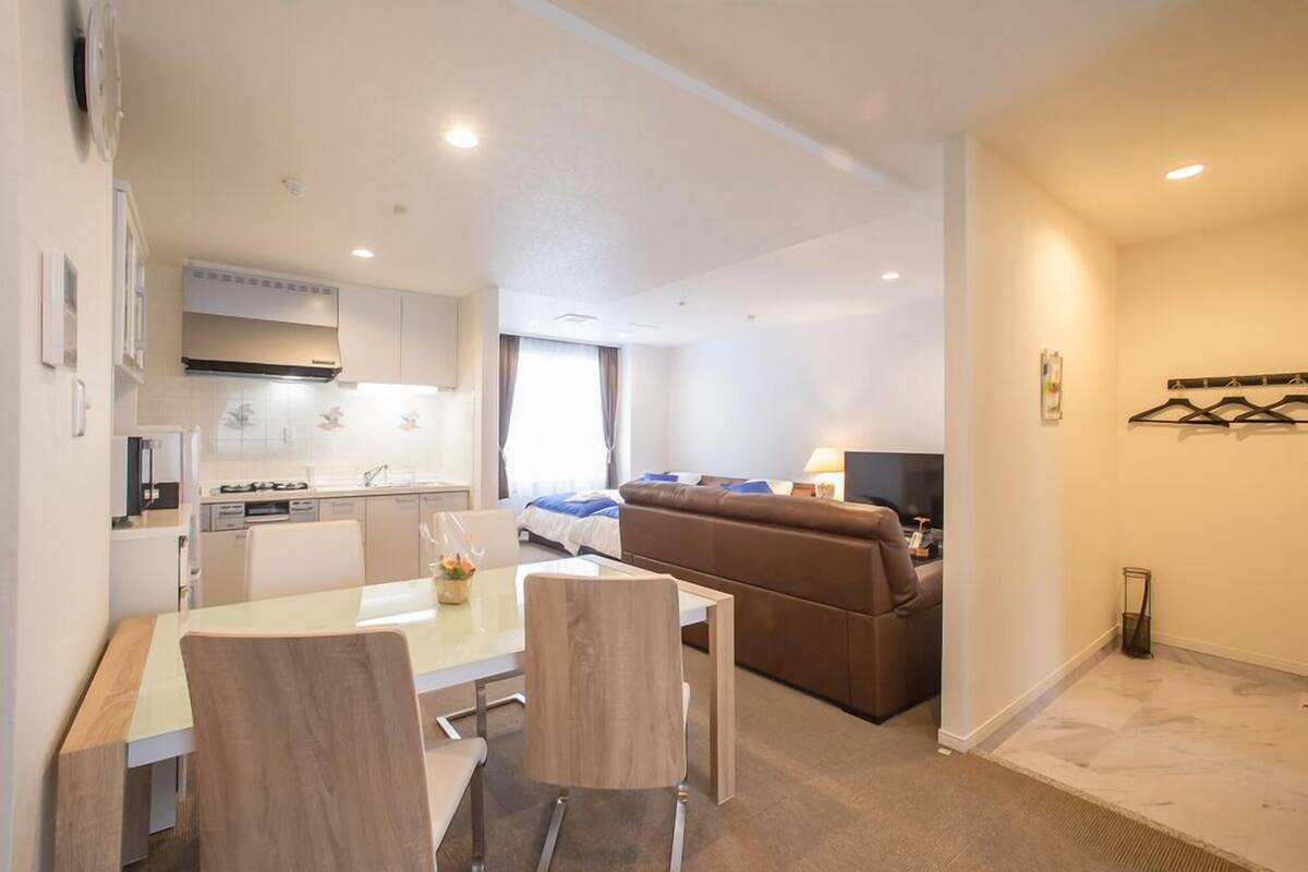 Un apartamento moderno con comedor, kitchenette, sala de estar y un sofá.