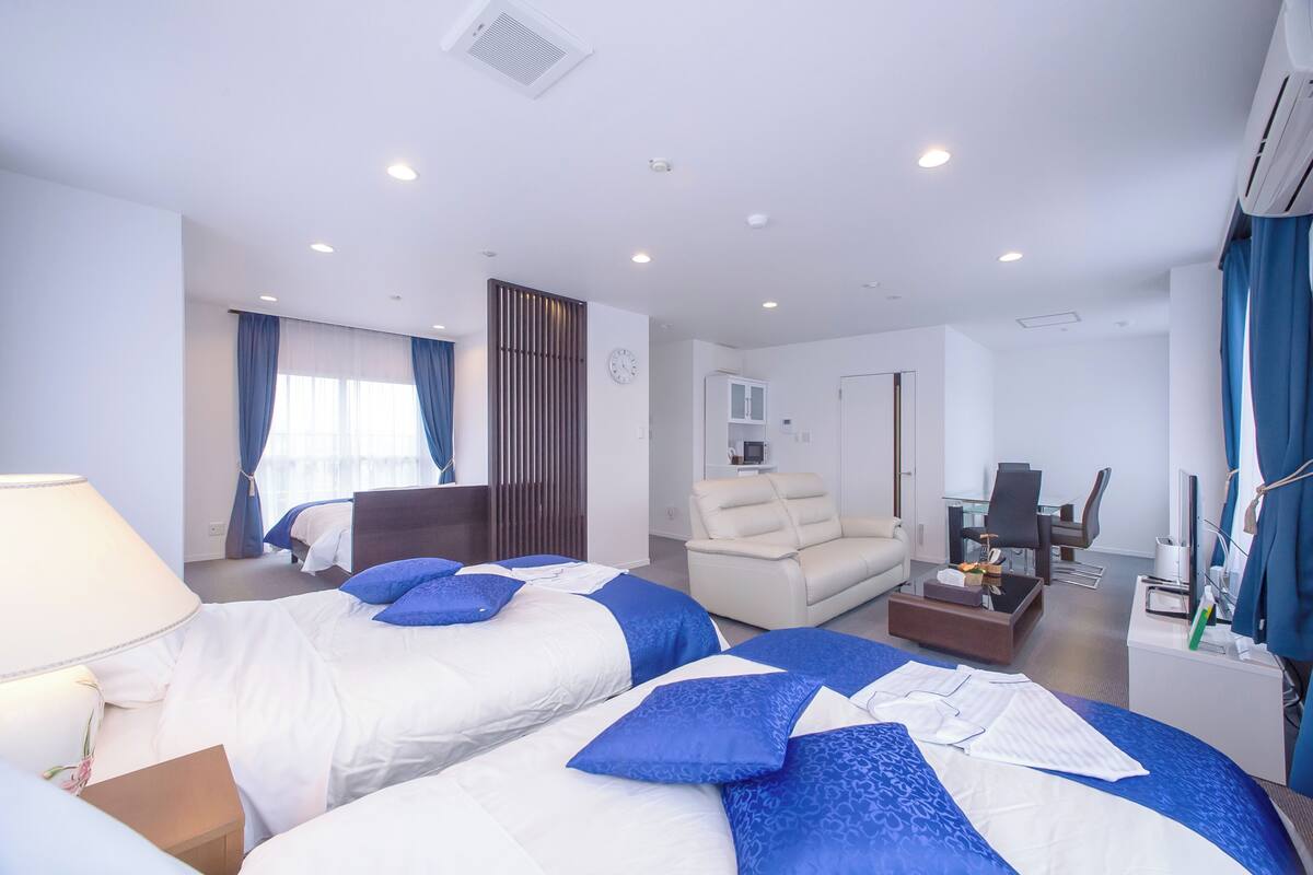 Una habitación de hotel con dos camas, un escritorio, una silla y un televisor.