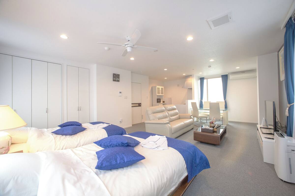 Una habitación de hotel con una cama grande, un sofá, un escritorio y un televisor.