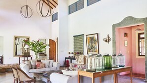 A spacious living room with a sofa, chairs, a coffee table, and a wooden table with glass jars. - Samadara Estate, Midigama (Ahangama)