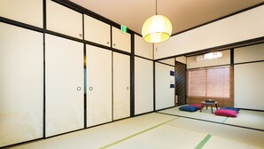 A traditional tatami room with sliding doors, a tatami mat floor, and a hanging paper lantern. - Otsu Ousaka House (Otsu)