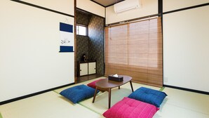 A traditional Japanese room with tatami flooring, a low table, and cushions. - Otsu Ousaka House (Otsu)