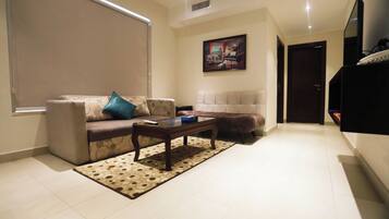 A living room with a sofa, a coffee table, and a patterned rug.