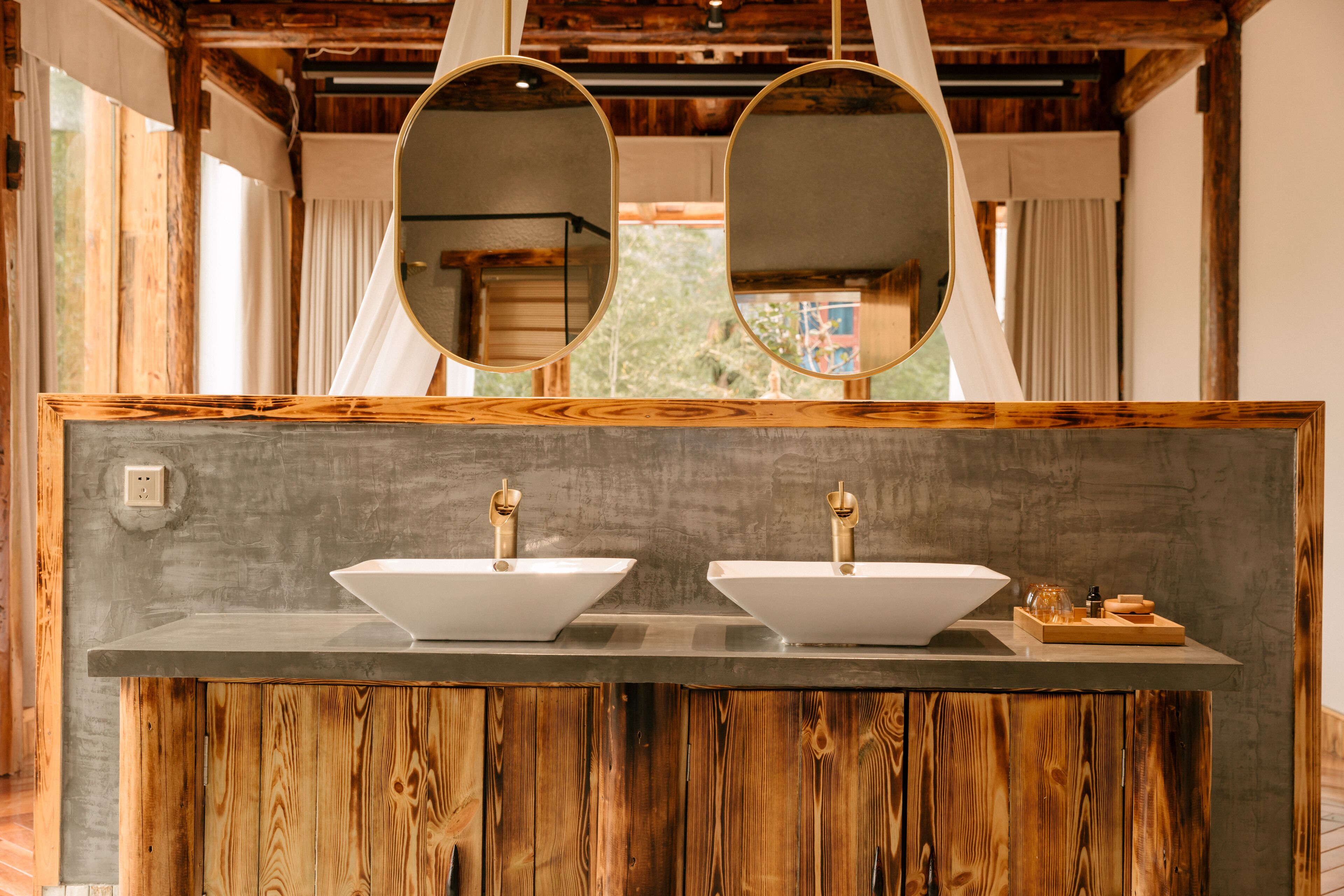 Ein Badezimmer mit zwei Waschbecken, Holzschränken und großen Spiegeln.