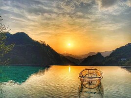 Una vista despejada de un barco sobre aguas tranquilas con un atardecer de fondo.